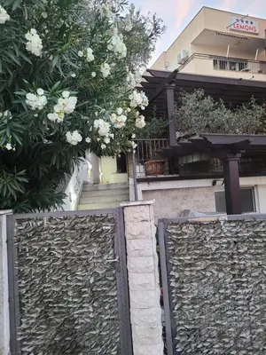 a fence in front of a building with white flowers at Sun & Sea Terrace Apartment in Becici