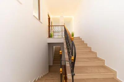 a staircase in a home with white walls and wooden floors at Villa Stella in Bar