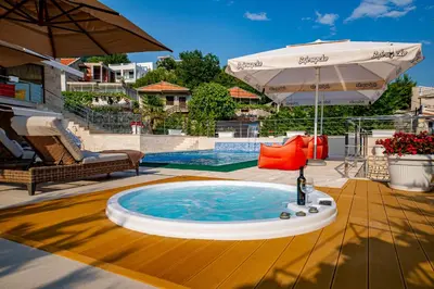 a hot tub with an umbrella on a patio at Villa Stella in Bar