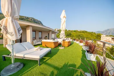 a patio with lawn chairs and umbrellas on a house at Villa Stella in Bar