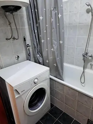 a washing machine in a bathroom with a shower curtain at Sunrise 2 in Podgorica
