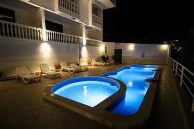 a swimming pool in the middle of a building at night at Aleksandra Apartments Utjeha in Utjeha