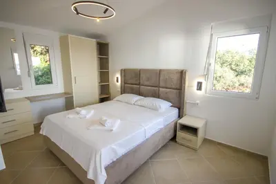 a bedroom with a large bed with two towels on it at Aleksandra Apartments Utjeha in Utjeha