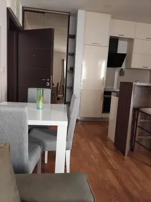 a white dining room table with chairs and a kitchen at Natali 1 in Budva