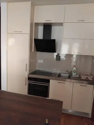 a kitchen with white cabinets and a sink and a stove at Natali 1 in Budva