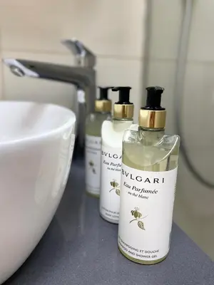 three bottles of soap on a counter next to a sink at Boka View Apartments in Kotor