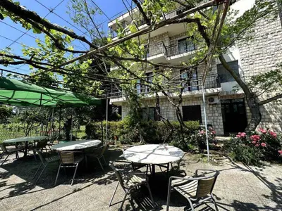 a patio with tables and chairs in front of a building at Greenfield campsite in Donji Štoj