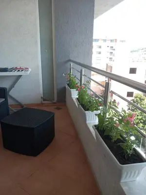 a balcony with potted plants on the side of a building at APARTMENTS ANI Ester in Ulcinj