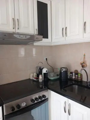 a kitchen with white cabinets and a black counter top at APARTMENTS ANI Ester in Ulcinj