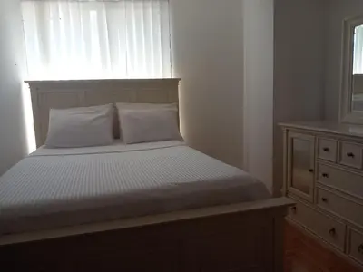 a bed in a bedroom with a window and a dresser at APARTMENTS ANI Ester in Ulcinj