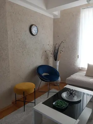 a living room with a couch and a clock on the wall at APARTMENTS ANI Ester in Ulcinj