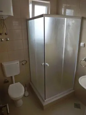 a bathroom with a shower with a toilet and a sink at Wonderful Seaview Apartment in Ulcinj