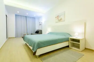 a bedroom with a green bed and a table and a window at LAReina- Best Buy in Ulcinj