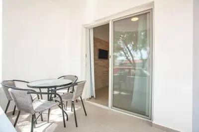 a balcony with a table and chairs and a glass door at LAReina- Best Buy in Ulcinj