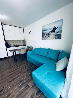 a living room with a blue couch and a table at Apartment Comfort A15 in Bar