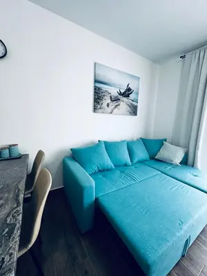 a living room with a blue couch in a room at Apartment Comfort A15 in Bar