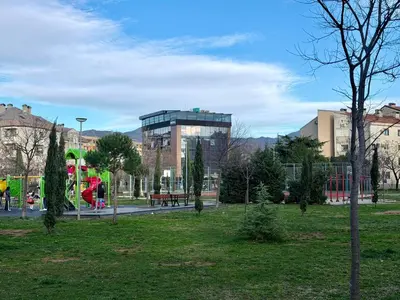 a park with a building in the background at Modern Apartment Free Parking Near Center in Podgorica