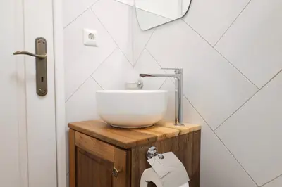 a bathroom with a white bowl sink on a wooden stand at Kotor Lovers in Kotor