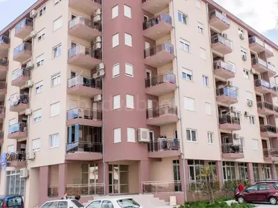 an apartment building with cars parked in front of it at Studio Maris in Budva