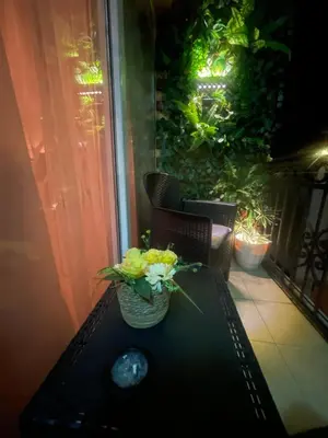 a table with a vase of flowers on a balcony at Lux Apartman David Dobra voda in Bar