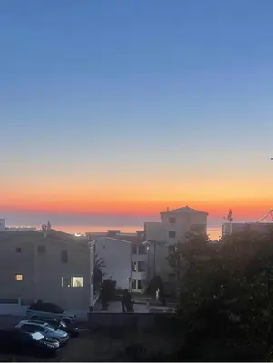 a sunset over a city with buildings and cars at Lux Apartman David Dobra voda in Bar