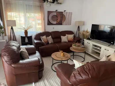 a living room with leather couches and a television at Lux Apartman David Dobra voda in Bar