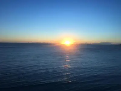 a sunset over the water with the sun in the sky at Wonder home in Sutomore