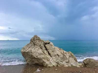 a large rock sitting on the beach next to the ocean at Wonder home in Sutomore