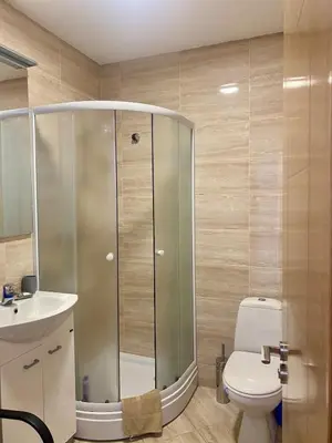 a bathroom with a shower with a toilet and a sink at Wonder home in Sutomore