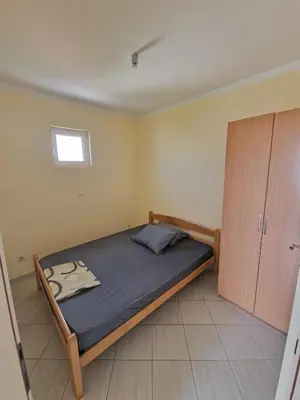 a small bedroom with a bed and a cabinet at Ago Apartman in Dobra Voda