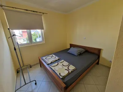 a small bedroom with a bed and a window at Ago Apartman in Dobra Voda