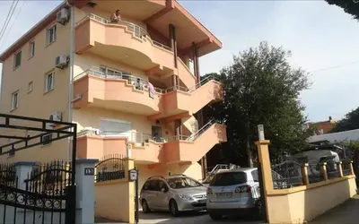 a building with two cars parked in front of it at Ago Apartman in Dobra Voda