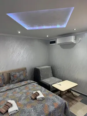 a room with a bed and a couch and a table at M&P FlyInn in Podgorica