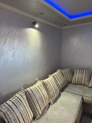 a bed with pillows on it with a blue ceiling at M&P FlyInn in Podgorica
