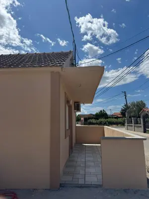 a small white house with a walkway at M&P FlyInn in Podgorica