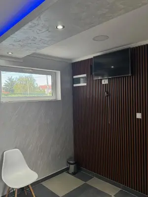 a room with a white chair and a window at M&P FlyInn in Podgorica