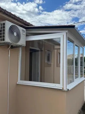 a window on the side of a house with a fan at M&P FlyInn in Podgorica