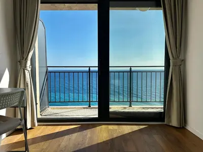 a room with a view of the ocean from a balcony at Seaview Retreat Reževići in Reževići