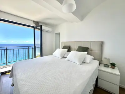 a bedroom with a large bed with a large window at Seaview Retreat Reževići in Reževići