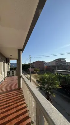 a balcony of a house with a palm tree on it at Apparteman donij stoj in Ulcinj