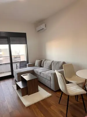 a living room with a couch and a table and chairs at Apartment LM lux in Ulcinj