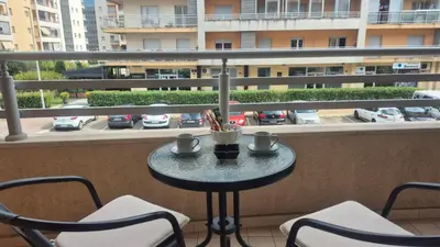 a small table on a balcony with chairs and cups at Premium City Kvart Apartment in Podgorica