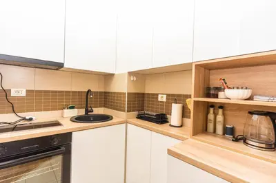 a kitchen with white cabinets and a sink at Premium City Kvart Apartment in Podgorica