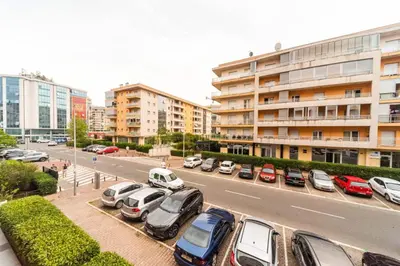 a parking lot with cars parked in front of a building at Premium City Kvart Apartment in Podgorica