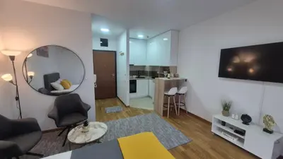 a living room with a large mirror and a kitchen at Premium City Kvart Apartment in Podgorica