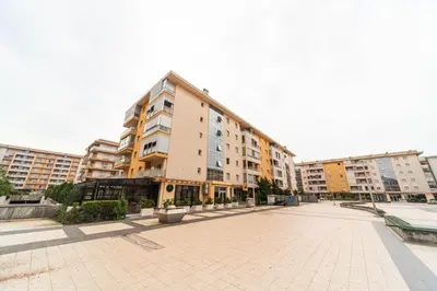 a large apartment building with a courtyard in front of it at Premium City Kvart Apartment in Podgorica
