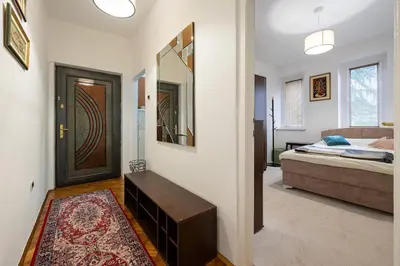 a room with a bed and a door with a mirror at Downtown Apartment Freedom in Podgorica