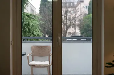 a chair sitting on a balcony next to a window at Downtown Apartment Freedom in Podgorica