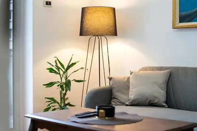 a lamp sitting in a living room next to a couch at Downtown Apartment Freedom in Podgorica