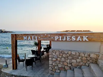 a restaurant on the beach next to the ocean at HELEN LUX Apartments in Dobra Voda